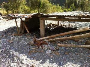 Structure of a house buried under debris washed in from the river.